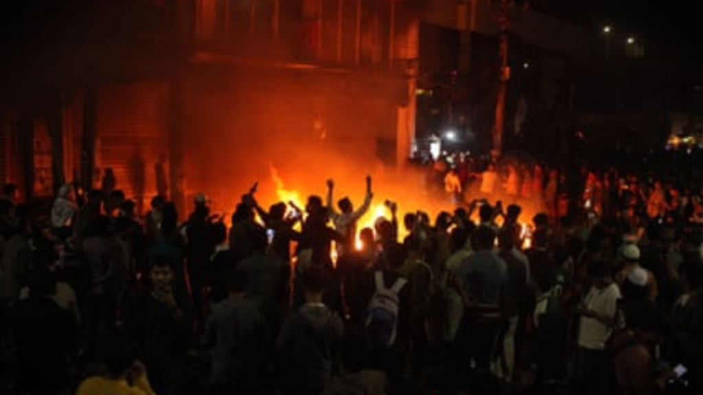 ढाका में रात के समय हिंसा और भीड़ का दृश्य, बांग्लादेश की अशांत स्थिति को दर्शाता हुआ