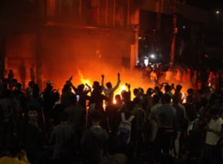 ढाका में रात के समय हिंसा और भीड़ का दृश्य, बांग्लादेश की अशांत स्थिति को दर्शाता हुआ